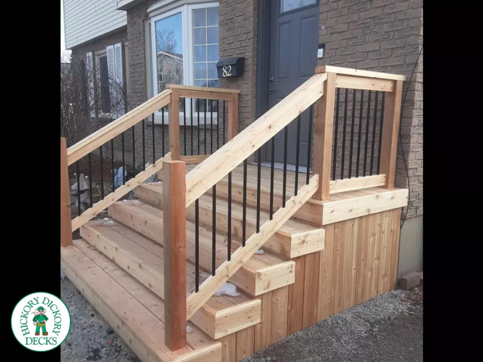 Small cedar porch with stairs and cedar railing.