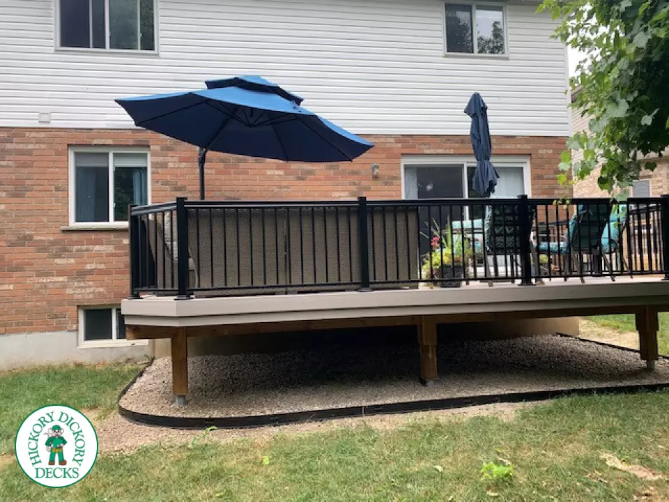 Mid size elevated deck built in grey composite with black railing.