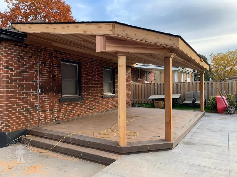 Small low brown composite deck with a dark brown border. and a custom roof structure.