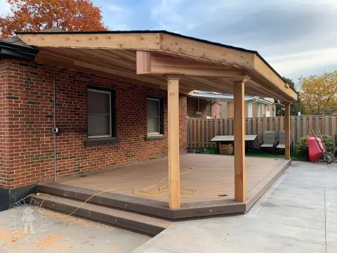 Small low brown composite deck with a dark brown border. and a custom roof structure.