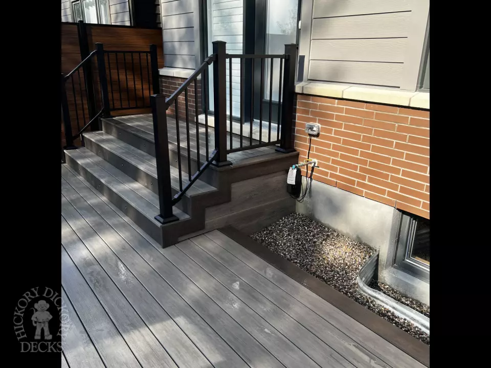 Grey Clubhouse deck with dark grey border, lighting in steps, and a custom bench.