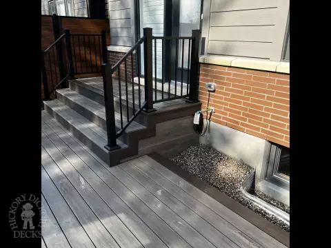 Grey Clubhouse deck with dark grey border, lighting in steps, and a custom bench.