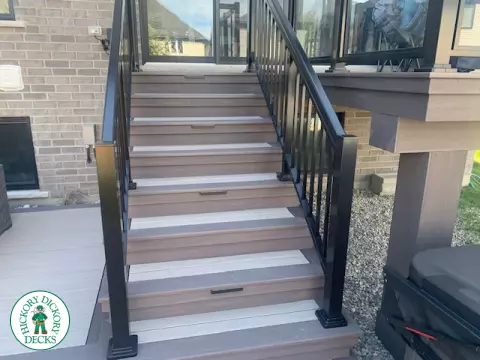 2 level brown composite deck with unique stairs and black aluminum railing. in Waterloo