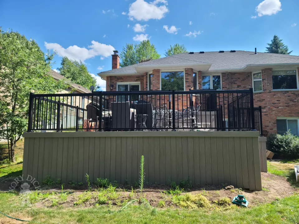 2 level grey composite deck with black aluminum railing.