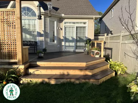 Mid size clubhouse deck in brown with cedar skirt, benches, planters, and a pergola.