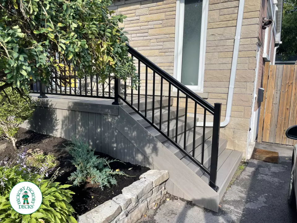 Grey composite front porch with black aluminum railing.