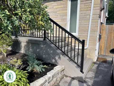 Grey composite front porch with black aluminum railing.
