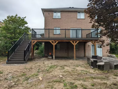 High clubhouse deck with stairs leading up to top, and black aluminum railing.