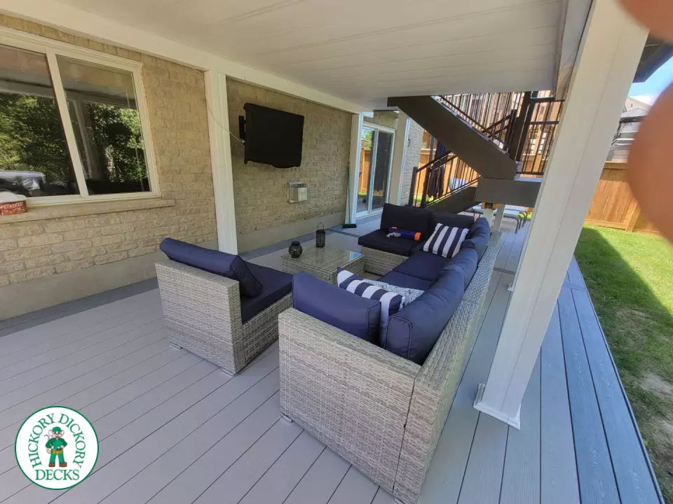 Multi level grey clubhouse deck with dark grey border and glass privacy screens on the top level.