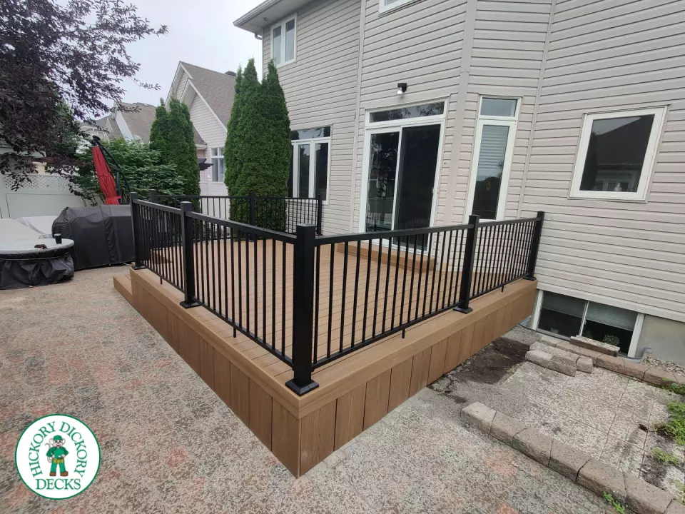 192 square foot fiberon in brown with three steps up to deck and black aluminum railing.