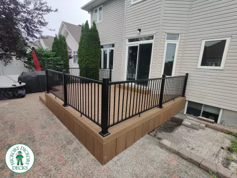 192 square foot fiberon in brown with three steps up to deck and black aluminum railing.