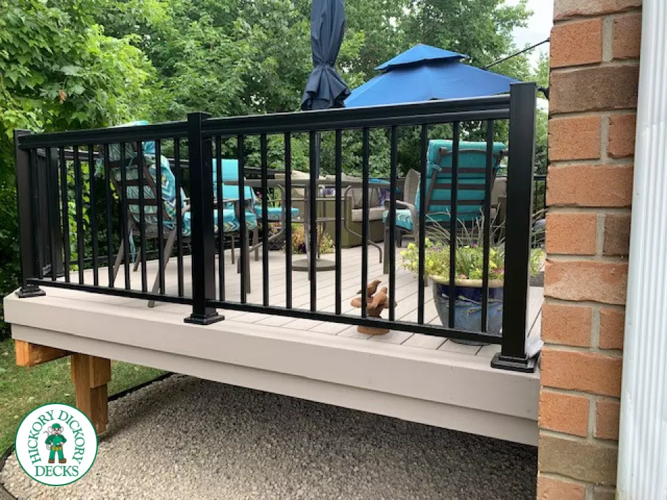 Mid size elevated deck built in grey composite with black railing.