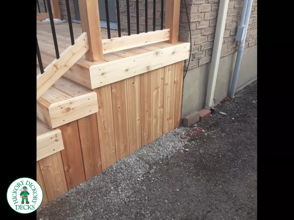 Small cedar porch with stairs and cedar railing.