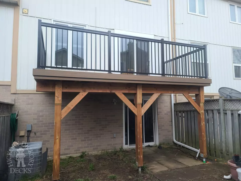 Dark brown Trex balcony with black aluminum railing.