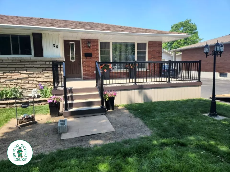 Large front porch in clay with a dark brown border and aluminum railings.