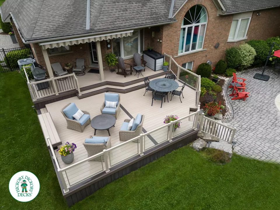 221 square foot light brown deck with dark brown border. This deck has curved steps and glass railings.