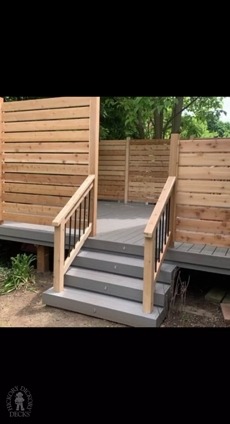 Grey fiberon deck with cedar railing and a cedar privacy screen.