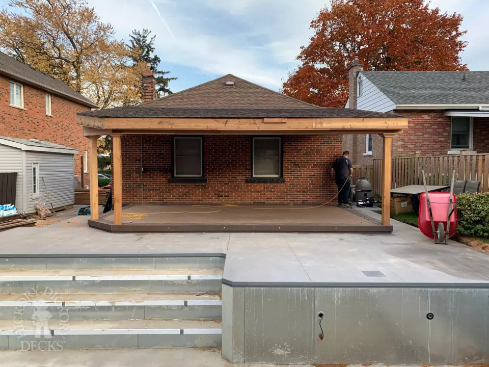 Small low brown composite deck with a dark brown border. and a custom roof structure.