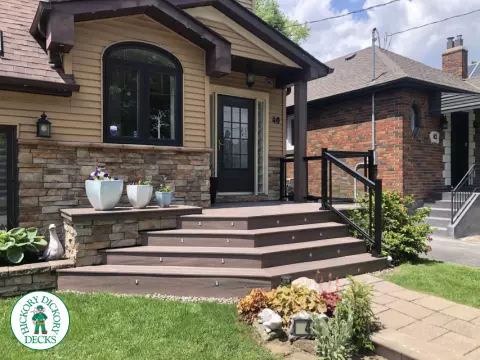 Brown porch with angled steps with lighting.