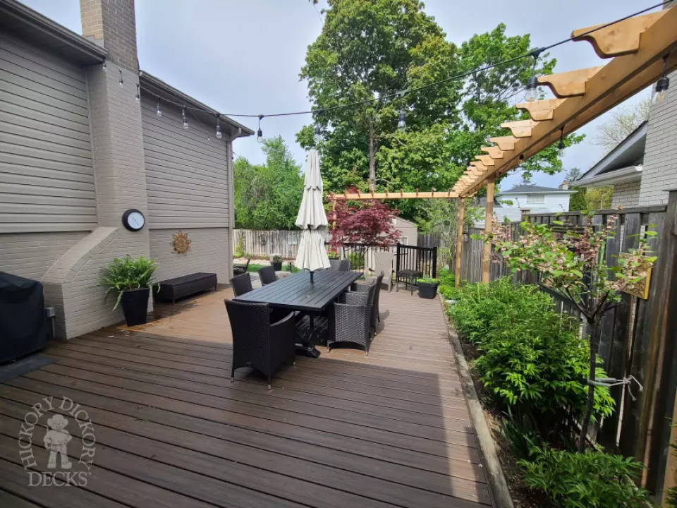 Trex deck in spiced rum loaded with features such as aluminum railings, a pergola, lighting and stairs