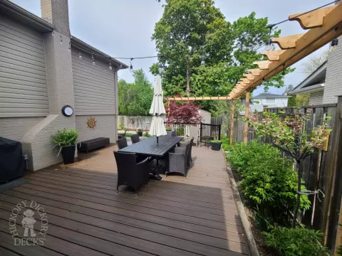 Trex deck in spiced rum loaded with features such as aluminum railings, a pergola, lighting and stairs