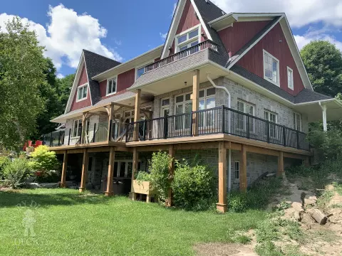 large high cedar deck with cedar pergola and black aluminum railing.