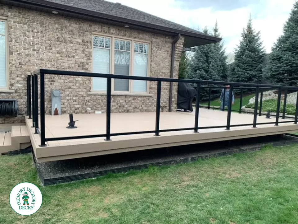 400 square foot beige composite deck with glass railings.