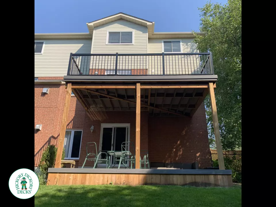 Balcony and deck both in grey Fiberon, with black aluminum railing on balcony.