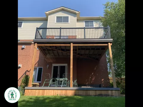 Balcony and deck both in grey Fiberon, with black aluminum railing on balcony.