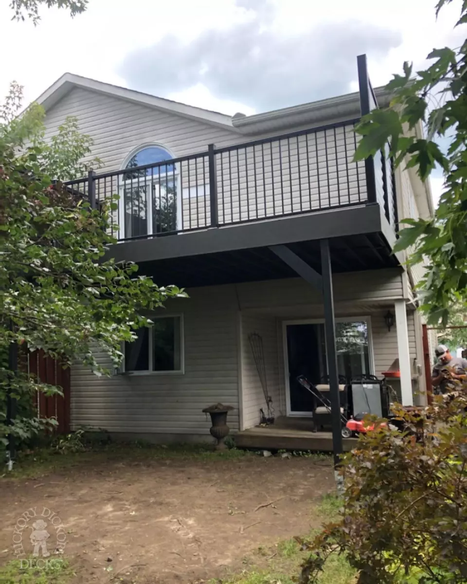 High clubhouse deck in dark grey with black aluminum railing and black privacy screen.