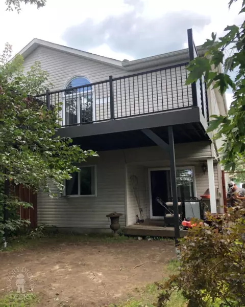 High clubhouse deck in dark grey with black aluminum railing and black privacy screen.