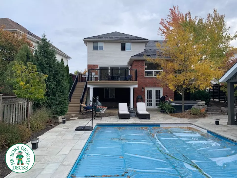 High composite deck with stairs that lead to pool and glass style railings.