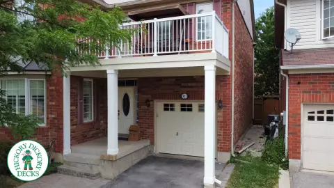 White balcony with white picket railing on front of house.