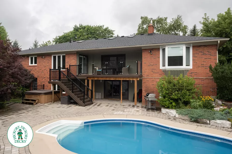 High brown deck with glass railings and lights in the stairs.