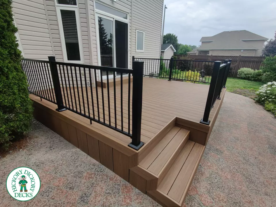 192 square foot fiberon in brown with three steps up to deck and black aluminum railing.