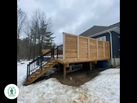Cedar deck with stairs leading to walk out deck with aluminum railing and a cedar privacy screen.