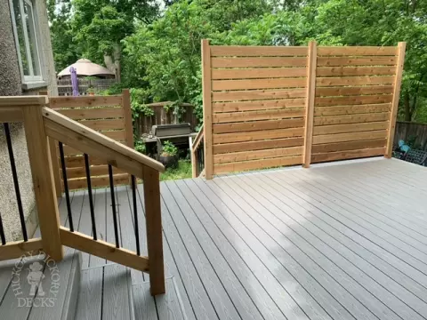 Grey fiberon deck with cedar railing and a cedar privacy screen.