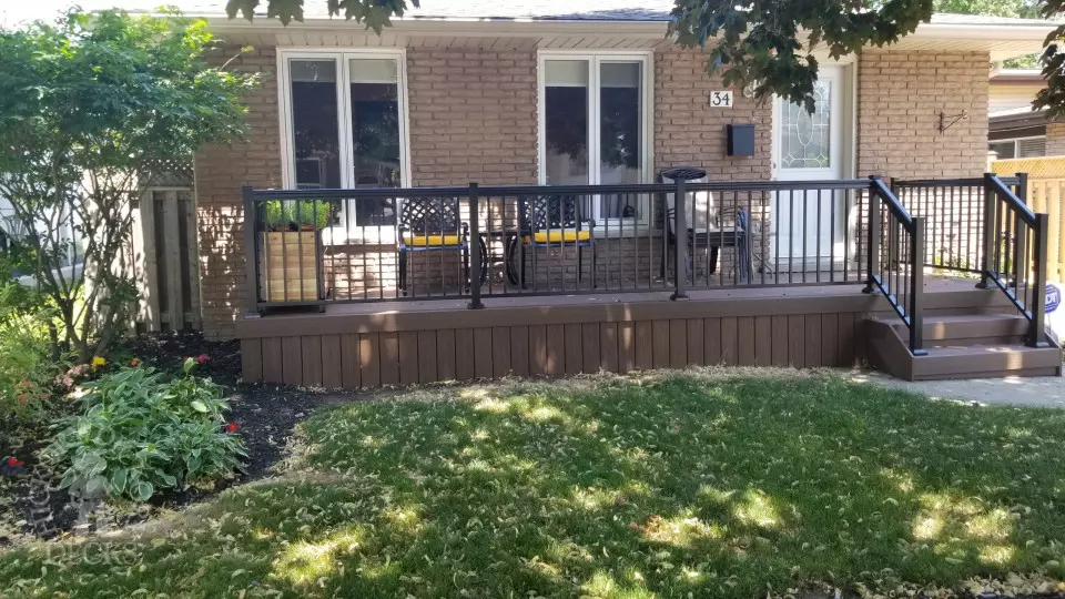 Small brown fiberon porch with black aluminum railing.