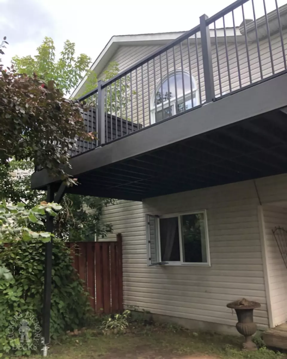 High clubhouse deck in dark grey with black aluminum railing and black privacy screen.