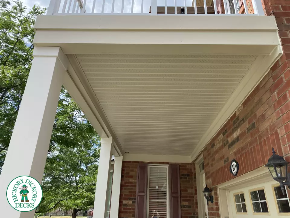 White balcony with white picket railing on front of house.