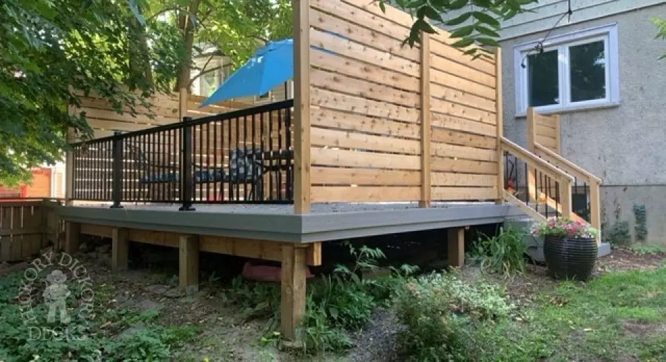 Grey fiberon deck with cedar railing and a cedar privacy screen.