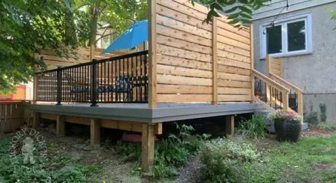 Grey fiberon deck with cedar railing and a cedar privacy screen.