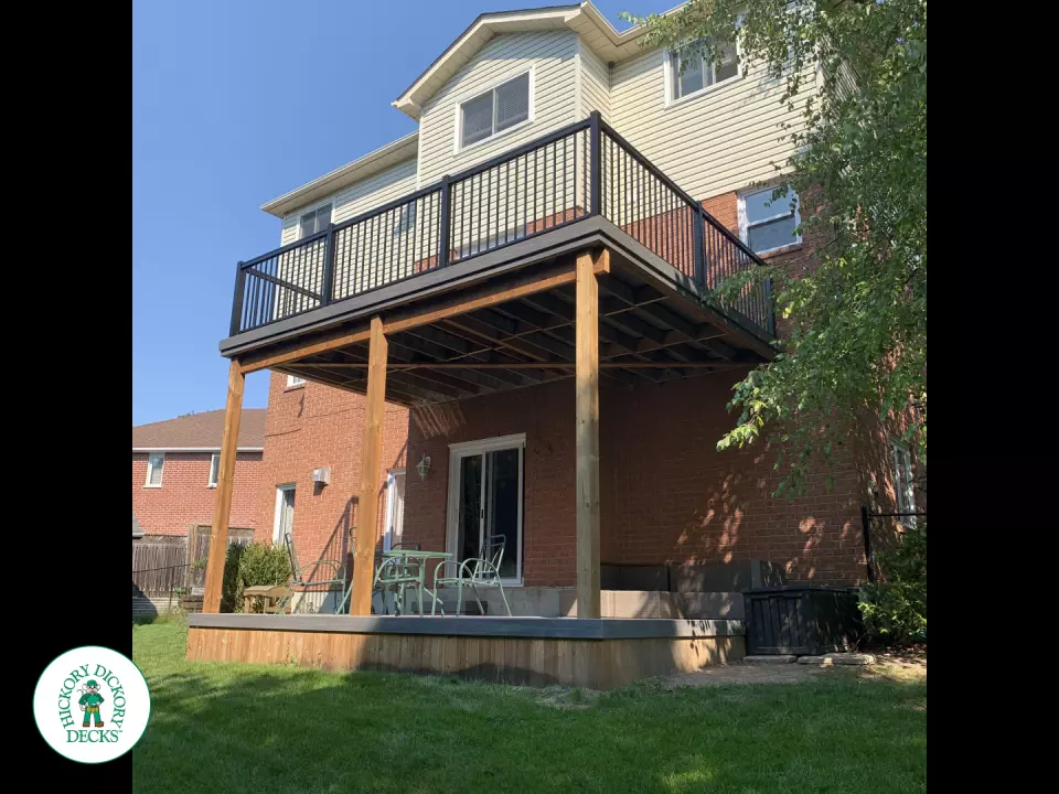 Balcony and deck both in grey Fiberon, with black aluminum railing on balcony.