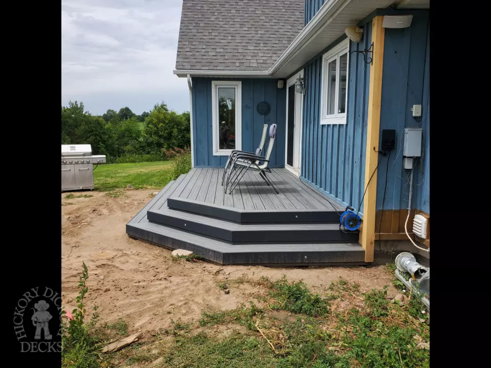 Small grey composite deck with angles steps leading to backyard