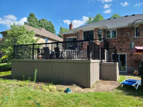 2 level grey composite deck with black aluminum railing.