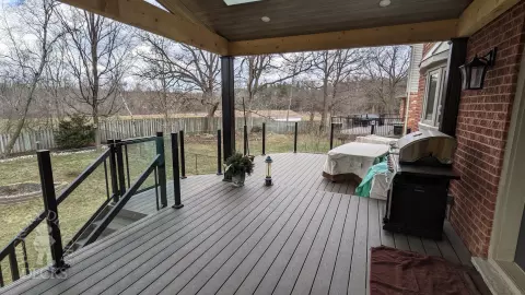 Large high Fiberon deck in brown. Glass railings and skylights in the custom roof structure.