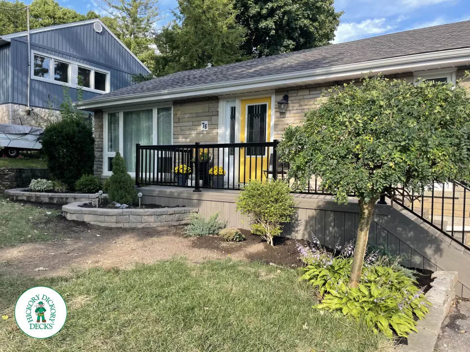 Grey composite front porch with black aluminum railing.