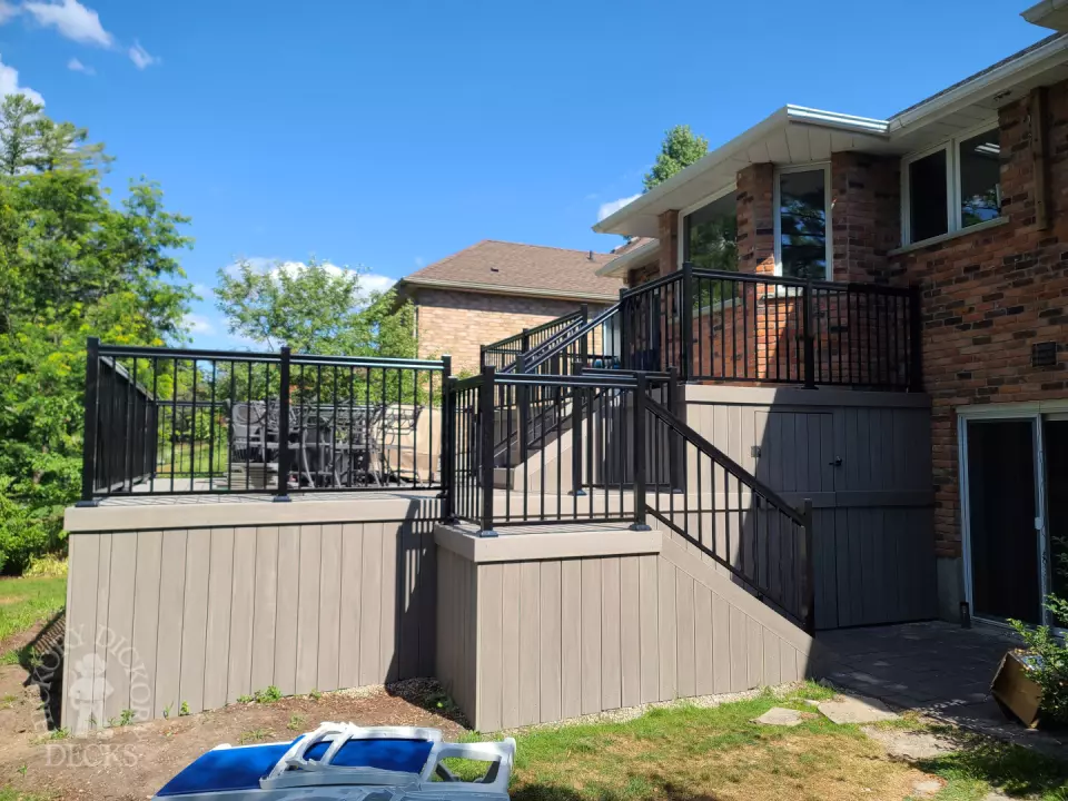 2 level grey composite deck with black aluminum railing.