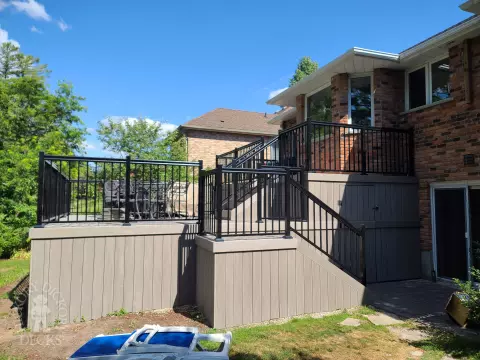 2 level grey composite deck with black aluminum railing.