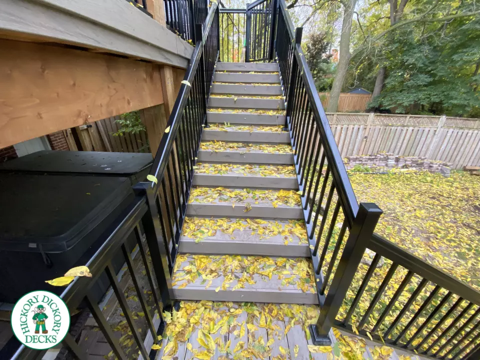Mid-high deck brown TruNorth deck with lighting in steps and black aluminum railing all around.
